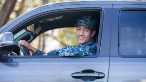 military car insurance discounts make this service member happy as he drives a car in a Navy uniform