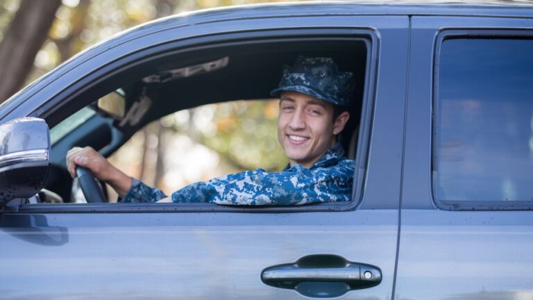 military car insurance discounts make this service member happy as he drives a car in a Navy uniform